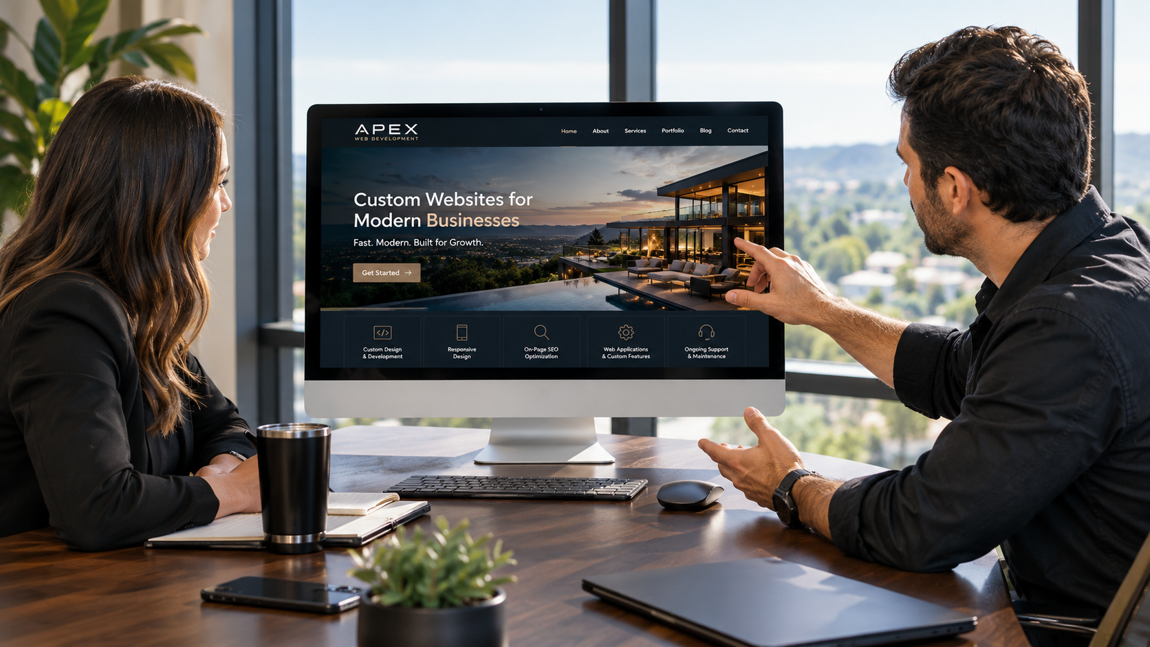 A business owner reviewing a custom website with a web development professional